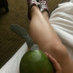 Emily Parker sitting in bed with piece of fruit