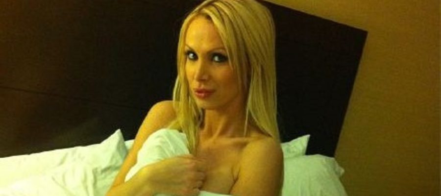 Nikki Benz in her bed under the covers looking sexy