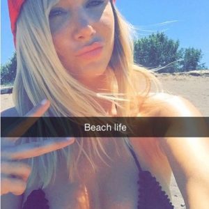 Gorgeous Sara Jean Underwood in red hat giving the peace sign