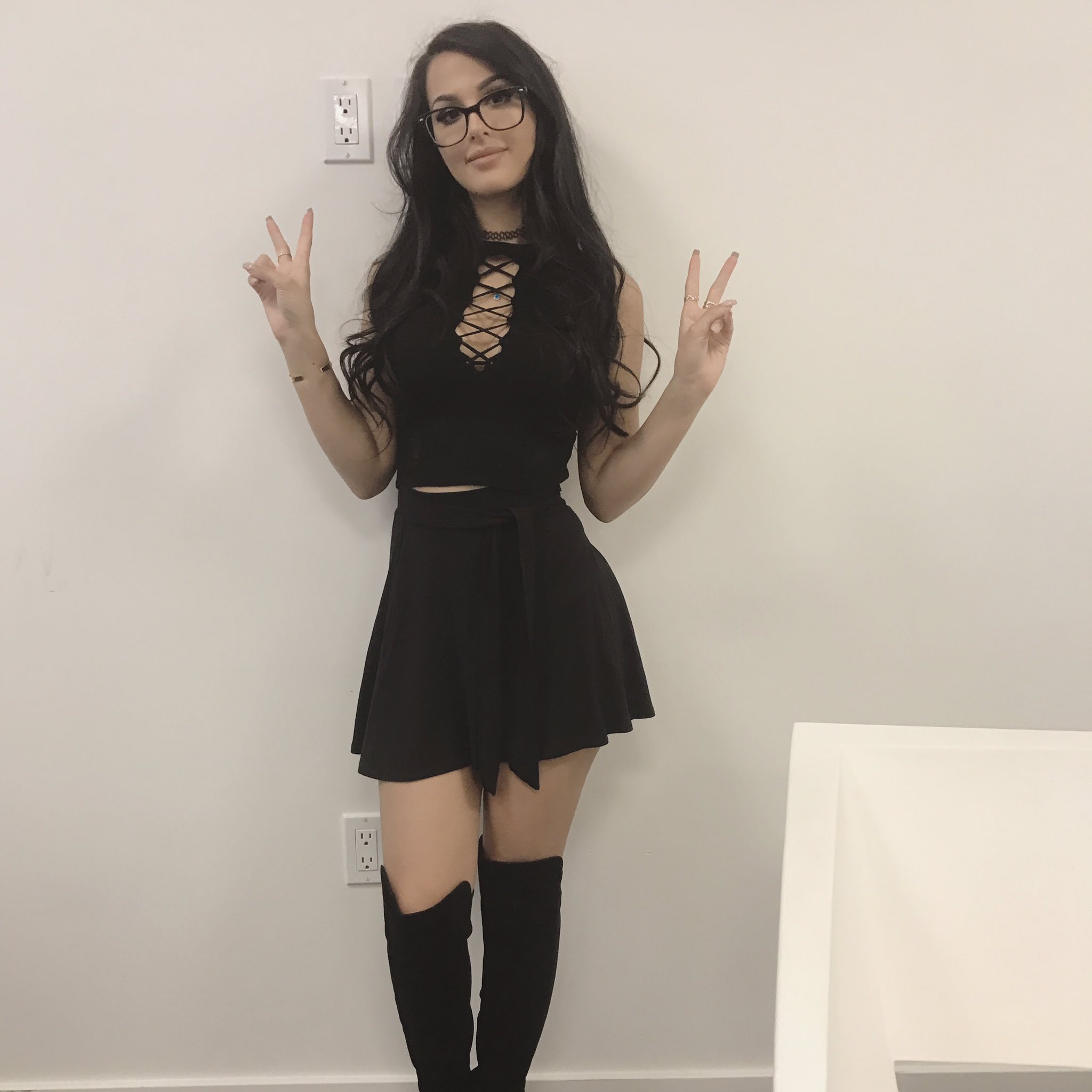 cosplay model sssniperwolf looking sexy in skirt and giving the peace sign